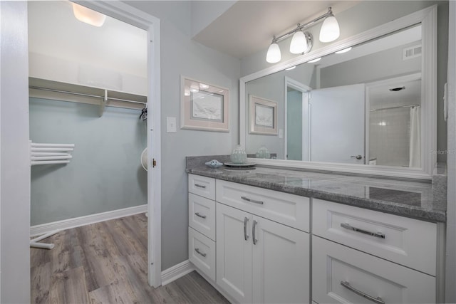 1155 Ocean Shore Blvd Unit 702, Ormond Beach, FL 32176 - full bath featuring wood finished floors, vanity, a shower with curtain, baseboards, and visible vents