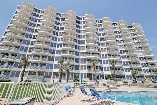 1155 Ocean Shore Blvd Unit 702, Ormond Beach, FL 32176 - view of building exterior with fence and a community pool