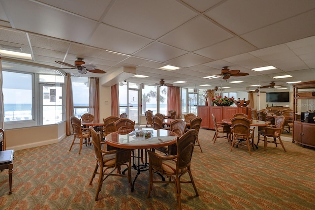 1155 Ocean Shore Blvd Unit 702, Ormond Beach, FL 32176 - dining space featuring carpet floors, a ceiling fan, a drop ceiling, and baseboards