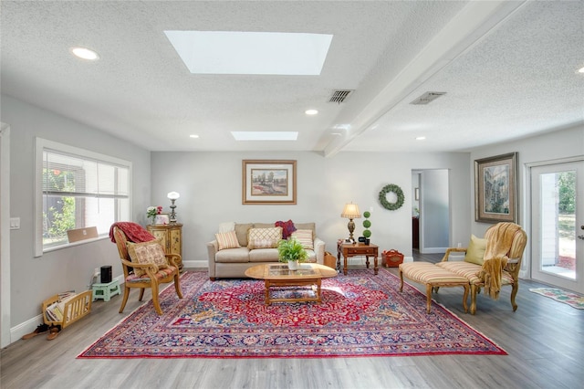 330 Wall Ave, Ormond Beach, FL 32174 - living area featuring a skylight, a textured ceiling, wood finished floors, and visible vents