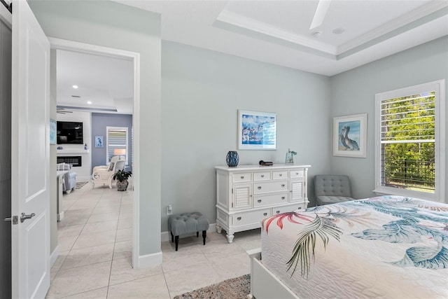 bedroom featuring a raised ceiling, baseboards, recessed lighting, a large fireplace, and light tile patterned floors