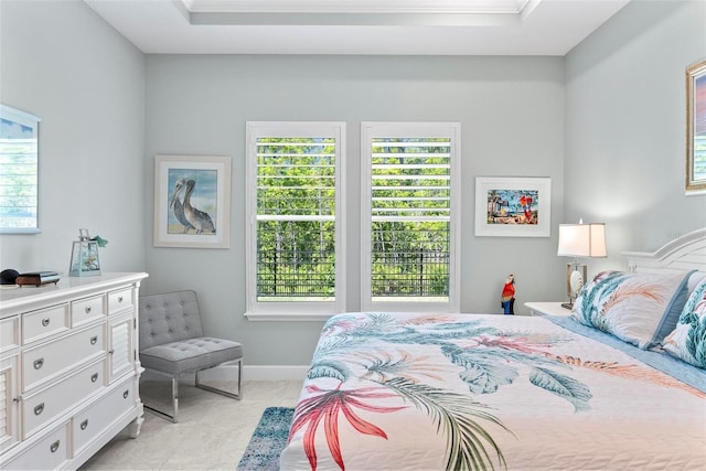 bedroom featuring a raised ceiling, baseboards, ornamental molding, and light tile patterned floors