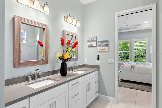 bathroom with tile patterned flooring, baseboards, a sink, and ceiling fan