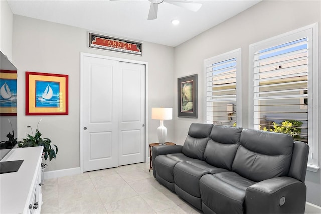 living area featuring light tile patterned flooring, a ceiling fan, baseboards, and recessed lighting