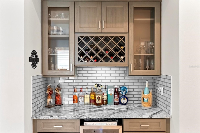 bar featuring backsplash and a bar