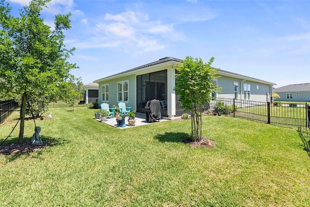rear view of property featuring a lawn, a fenced backyard, and a patio
