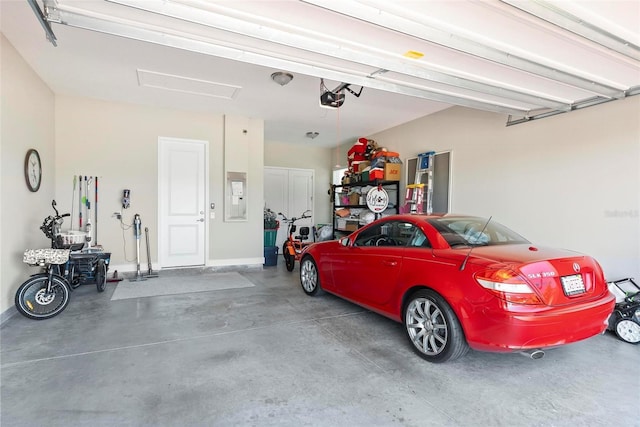 garage featuring electric panel, baseboards, and a garage door opener