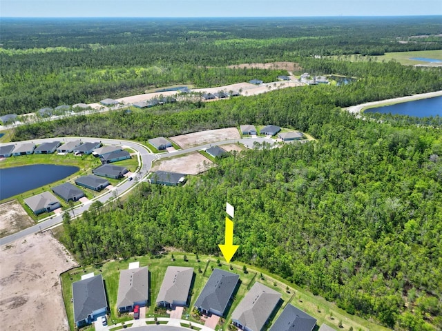 birds eye view of property featuring a view of trees, a residential view, and a water view