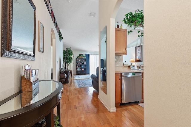 9 Pittman Dr, Palm Coast, FL 32164 - corridor featuring a textured wall, visible vents, arched walkways, and light wood-style floors