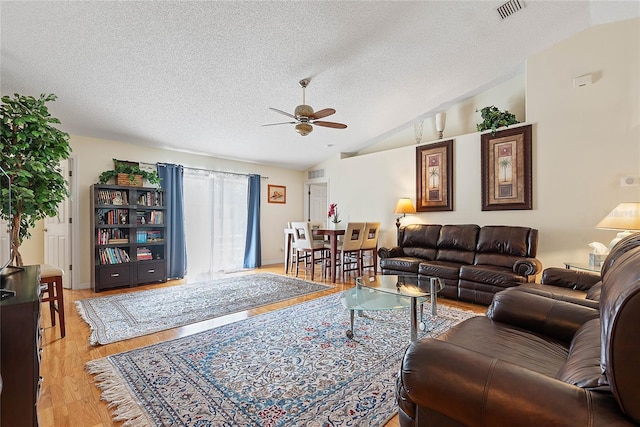 9 Pittman Dr, Palm Coast, FL 32164 - living area featuring a textured ceiling, vaulted ceiling, visible vents, light wood-style floors, and a ceiling fan
