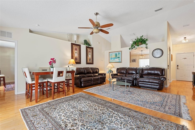 9 Pittman Dr, Palm Coast, FL 32164 - living room featuring vaulted ceiling, visible vents, a ceiling fan, wood finished floors, and a textured ceiling