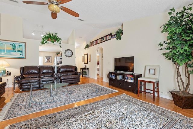 9 Pittman Dr, Palm Coast, FL 32164 - living area with lofted ceiling, wood finished floors, a ceiling fan, arched walkways, and a textured ceiling