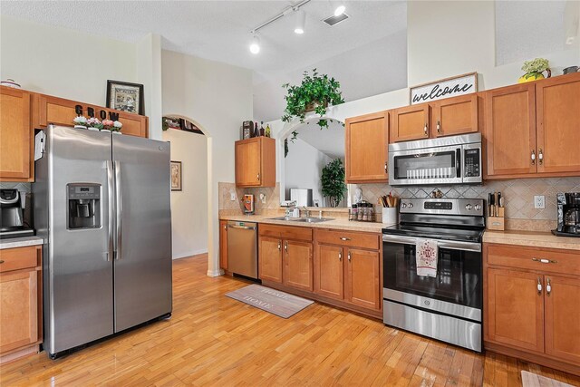 9 Pittman Dr, Palm Coast, FL 32164 - kitchen with light countertops, backsplash, light wood-style flooring, and appliances with stainless steel finishes
