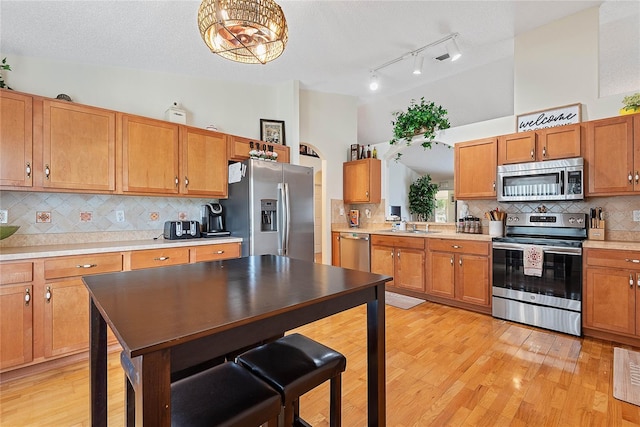 9 Pittman Dr, Palm Coast, FL 32164 - kitchen featuring light wood finished floors, light countertops, backsplash, and appliances with stainless steel finishes