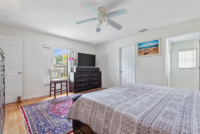 9 Pittman Dr, Palm Coast, FL 32164 - bedroom featuring a ceiling fan, wood finished floors, a textured ceiling, baseboards, and visible vents