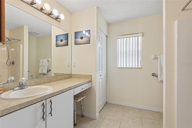 9 Pittman Dr, Palm Coast, FL 32164 - bathroom with tile patterned flooring, vanity, baseboards, walk in shower, and a textured ceiling