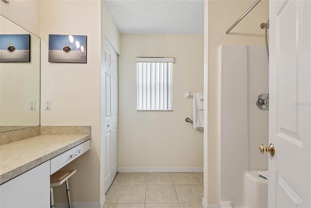9 Pittman Dr, Palm Coast, FL 32164 - bathroom with tile patterned flooring, vanity, a textured ceiling, and a shower