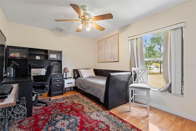 9 Pittman Dr, Palm Coast, FL 32164 - bedroom with a ceiling fan, baseboards, a textured ceiling, and light wood-style floors