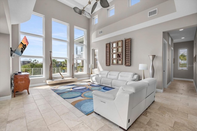 2590 Palm Ave, Flagler Beach, FL 32136 - living area featuring a ceiling fan, a high ceiling, and plenty of natural light