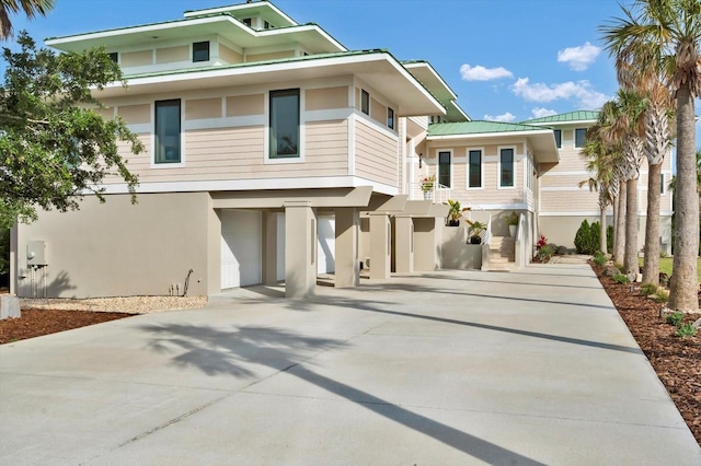 2590 Palm Ave, Flagler Beach, FL 32136 - view of front of home with driveway, stucco siding, a carport, a garage, and a metal roof