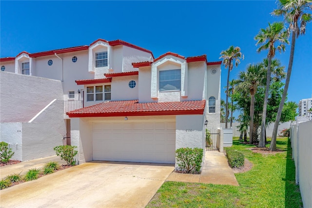 200 Florida Shores Blvd, Daytona Beach, FL 32118 - mediterranean / spanish home with a tile roof, driveway, an attached garage, fence, and stucco siding