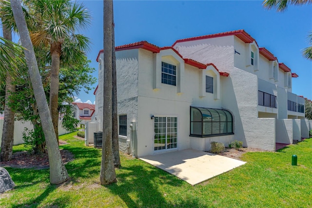 200 Florida Shores Blvd, Daytona Beach, FL 32118 - rear view of property featuring a tiled roof, central AC, stucco siding, a patio area, and a lawn