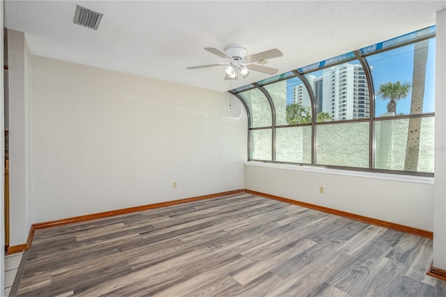 200 Florida Shores Blvd, Daytona Beach, FL 32118 - spare room featuring a textured ceiling, baseboards, visible vents, wood finished floors, and ceiling fan
