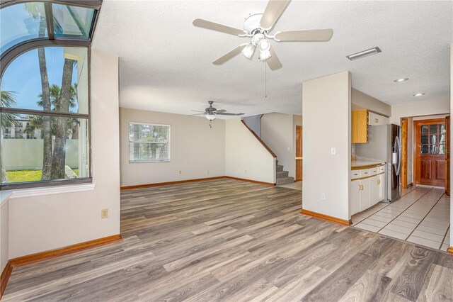 200 Florida Shores Blvd, Daytona Beach, FL 32118 - unfurnished living room with a textured ceiling, light wood finished floors, baseboards, and visible vents