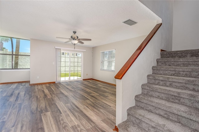 200 Florida Shores Blvd, Daytona Beach, FL 32118 - stairway with wood finished floors, visible vents, a ceiling fan, baseboards, and a textured ceiling