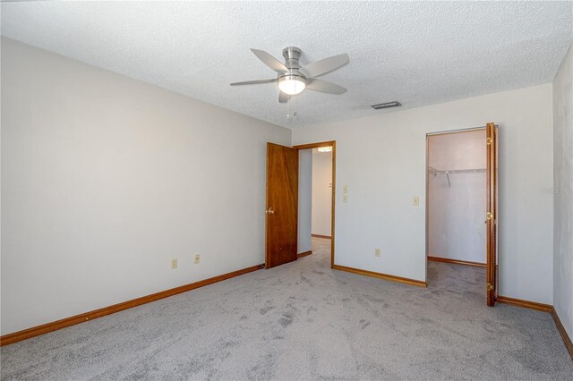 200 Florida Shores Blvd, Daytona Beach, FL 32118 - unfurnished bedroom featuring a ceiling fan, a walk in closet, carpet, baseboards, and visible vents