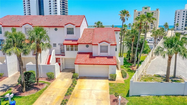 200 Florida Shores Blvd, Daytona Beach, FL 32118 - mediterranean / spanish home featuring a garage, concrete driveway, a tiled roof, and stucco siding