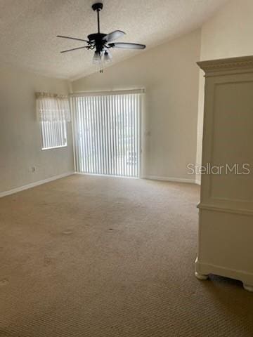 5 Nantucket Dr, Palm Coast, FL 32137 - spare room featuring light carpet, a textured ceiling, baseboards, lofted ceiling, and ceiling fan