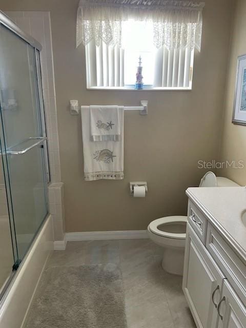 5 Nantucket Dr, Palm Coast, FL 32137 - full bath with tile patterned flooring, combined bath / shower with glass door, toilet, vanity, and baseboards