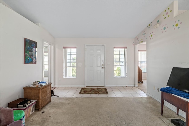 carpeted entrance foyer featuring baseboards and tile patterned flooring