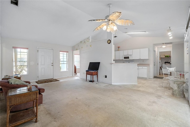 living room featuring high vaulted ceiling, ceiling fan, baseboards, and light carpet