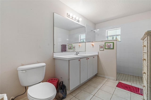 full bathroom featuring tile patterned flooring, toilet, vanity, a walk in shower, and a textured ceiling