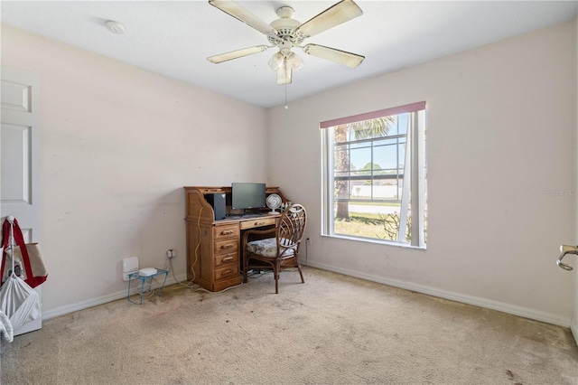 carpeted office featuring baseboards and ceiling fan