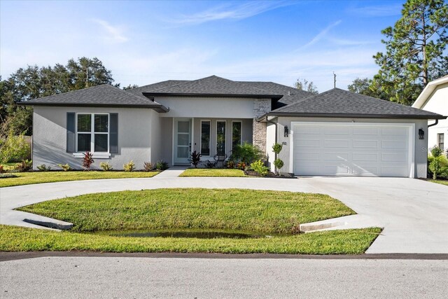 45 Fenhill, Palm Coast, FL 32137 - prairie-style home featuring stucco siding, concrete driveway, a front lawn, and a garage