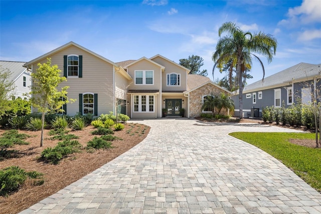 28 Cinnamon Grove Ln, Palm Coast, FL 32137 - view of front of property with decorative driveway, central AC, and french doors