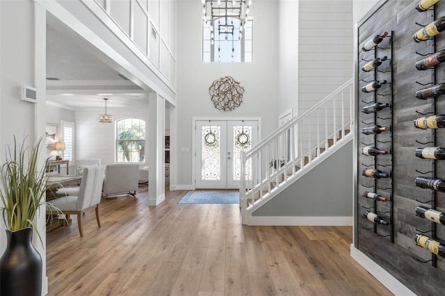 28 Cinnamon Grove Ln, Palm Coast, FL 32137 - foyer entrance with an inviting chandelier, stairs, wood finished floors, baseboards, and french doors