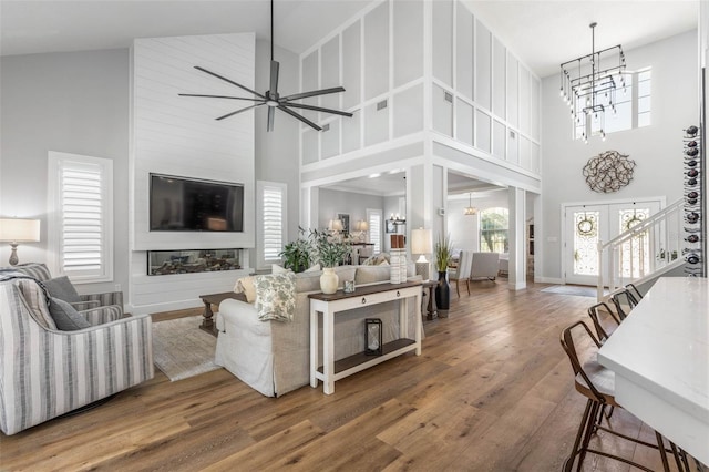 28 Cinnamon Grove Ln, Palm Coast, FL 32137 - living area featuring baseboards, wood finished floors, ceiling fan with notable chandelier, and a towering ceiling