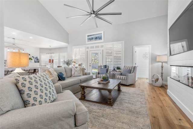 28 Cinnamon Grove Ln, Palm Coast, FL 32137 - living area with wood finished floors, a chandelier, high vaulted ceiling, and a healthy amount of sunlight