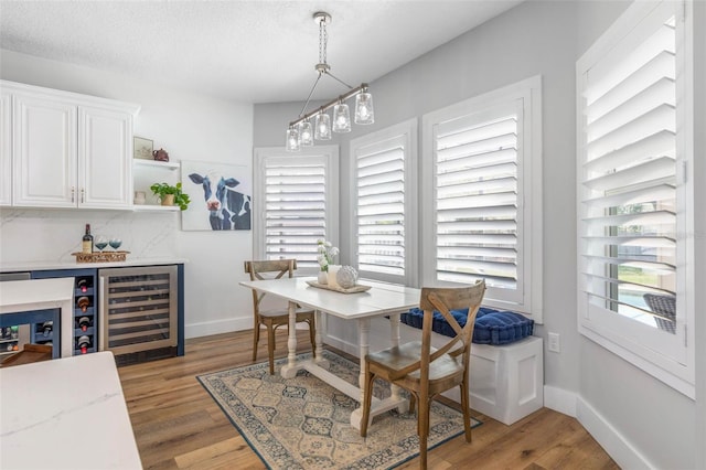 28 Cinnamon Grove Ln, Palm Coast, FL 32137 - dining space with wine cooler, baseboards, a dry bar, and light wood-type flooring
