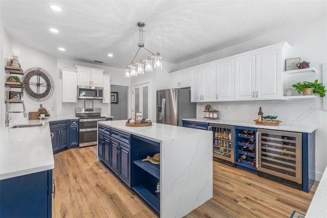 28 Cinnamon Grove Ln, Palm Coast, FL 32137 - kitchen featuring open shelves, wine cooler, a sink, appliances with stainless steel finishes, and blue cabinetry