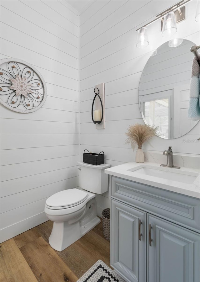 28 Cinnamon Grove Ln, Palm Coast, FL 32137 - half bathroom featuring wooden walls, vanity, toilet, and wood finished floors