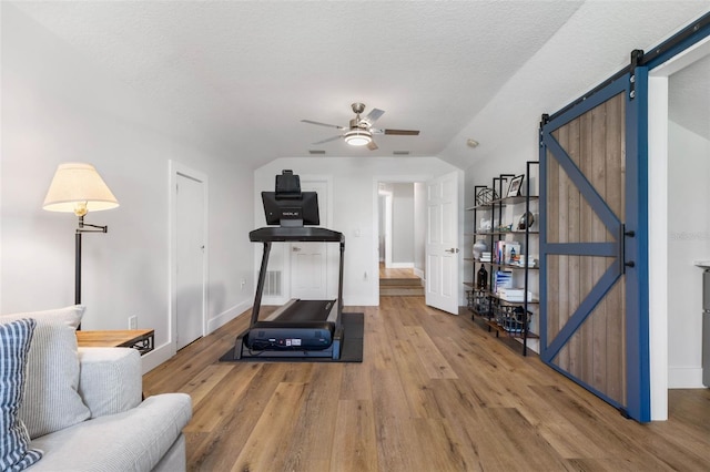 28 Cinnamon Grove Ln, Palm Coast, FL 32137 - exercise area featuring wood finished floors, lofted ceiling, baseboards, ceiling fan, and a barn door