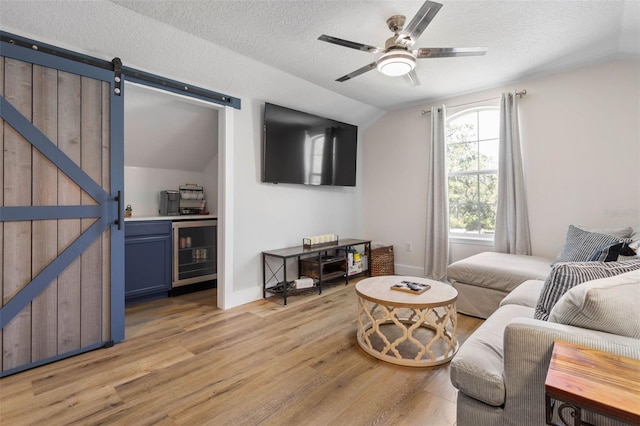 28 Cinnamon Grove Ln, Palm Coast, FL 32137 - living area featuring a barn door, light wood finished floors, beverage cooler, a ceiling fan, and vaulted ceiling