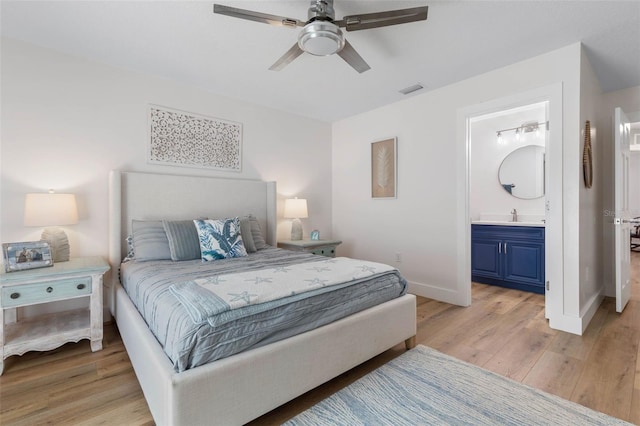 28 Cinnamon Grove Ln, Palm Coast, FL 32137 - bedroom with connected bathroom, a sink, light wood-style floors, baseboards, and visible vents