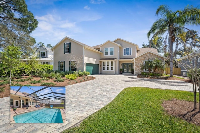 28 Cinnamon Grove Ln, Palm Coast, FL 32137 - view of front of property featuring stone siding, an outdoor pool, decorative driveway, french doors, and glass enclosure