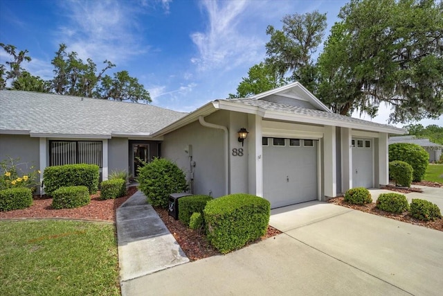ranch-style house with stucco siding, roof with shingles, concrete driveway, and a garage